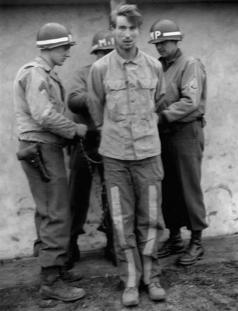 Американские военные полицейские на рассвете 23 декабря 1944 г. привязывают унтер-офицера Манфреда Пернасса к расстрельному столбу. По нормам военного права солдаты, схваченные в форме противника, предавались смертной казни.