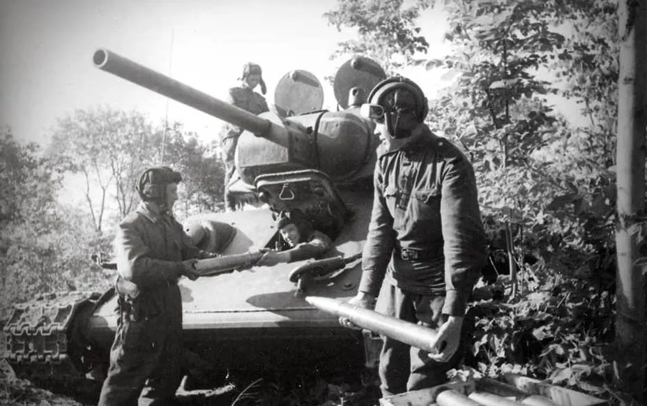 Готовясь к боям советские танкисты загружают боеприпасы в тридцатьчетверку