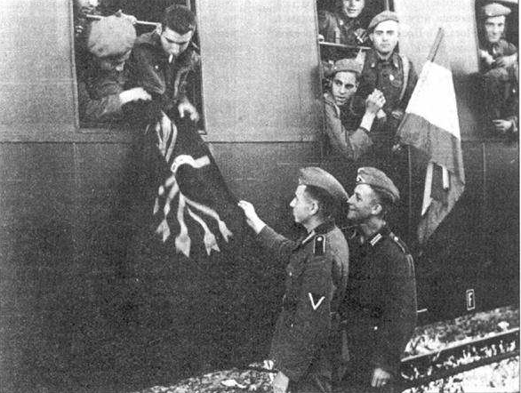 Испанский доброволец демонстрирует черный фалангистский флаг немецким солдатам