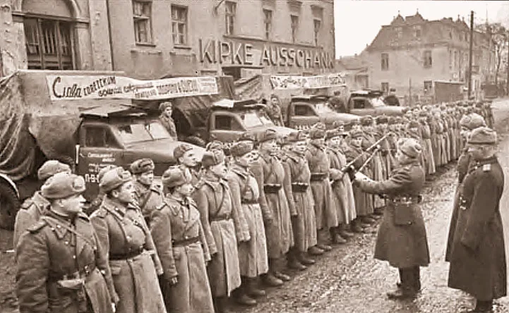 В перерывах между залпами гвардейцы-минометчики выстроились на отвоеванной улице города Бреслау, чтобы заслушать приказ Верховного Главнокомандующего в день 27-й годовщины Красной Армии